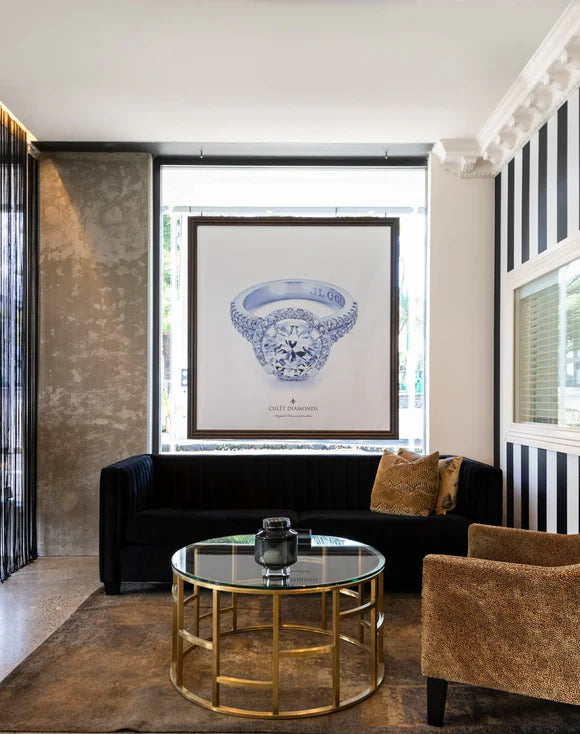 Inside the Culét Auckland showroom — a large framed diamond ring portrait above a velvet sofa and brass-and-glass coffee table